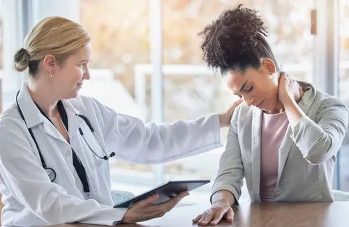 paciente mostrando síntomas de lesiones por latigazo cervical en Inspine Chiropractic mientras es evaluado durante una consulta gratuita.