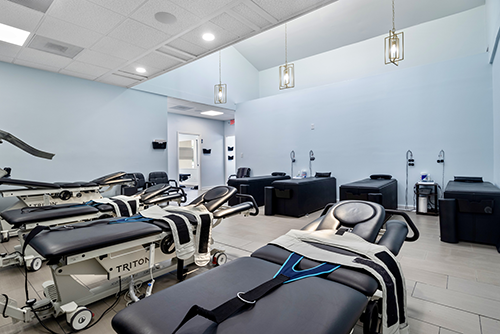 Treatment room at the Dalton clinic with Triton therapy tables and a blue color scheme.