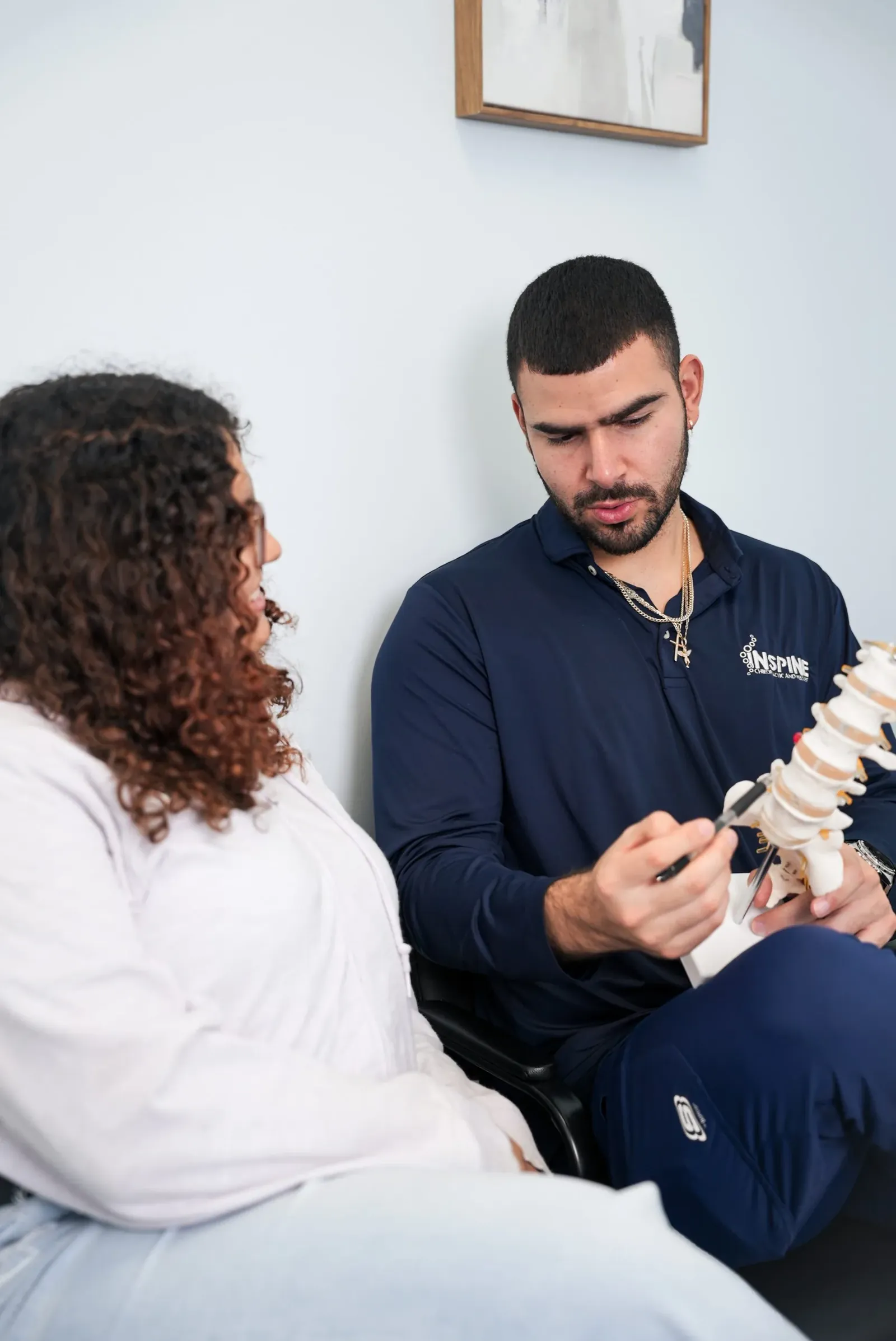 A chiropractor assessing a new patient's spine during an initial evaluation.