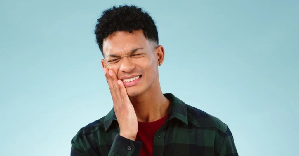 man-experiencing-pain-from-tmj-while-touching-jaw