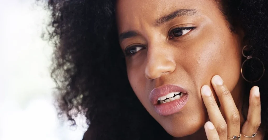 woman-touching-her-jaw-in-discomfort-due-to-tmj