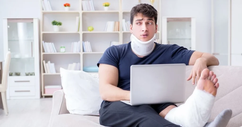 man-with-neck-brace-and-cast-using-laptop-after-whiplash-injury