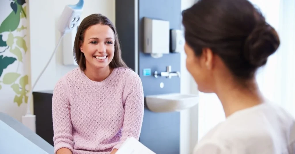 chiropractor-smiling-and-holding-clipboard-in-office