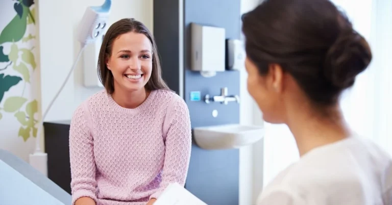 chiropractor-smiling-and-holding-clipboard-in-office